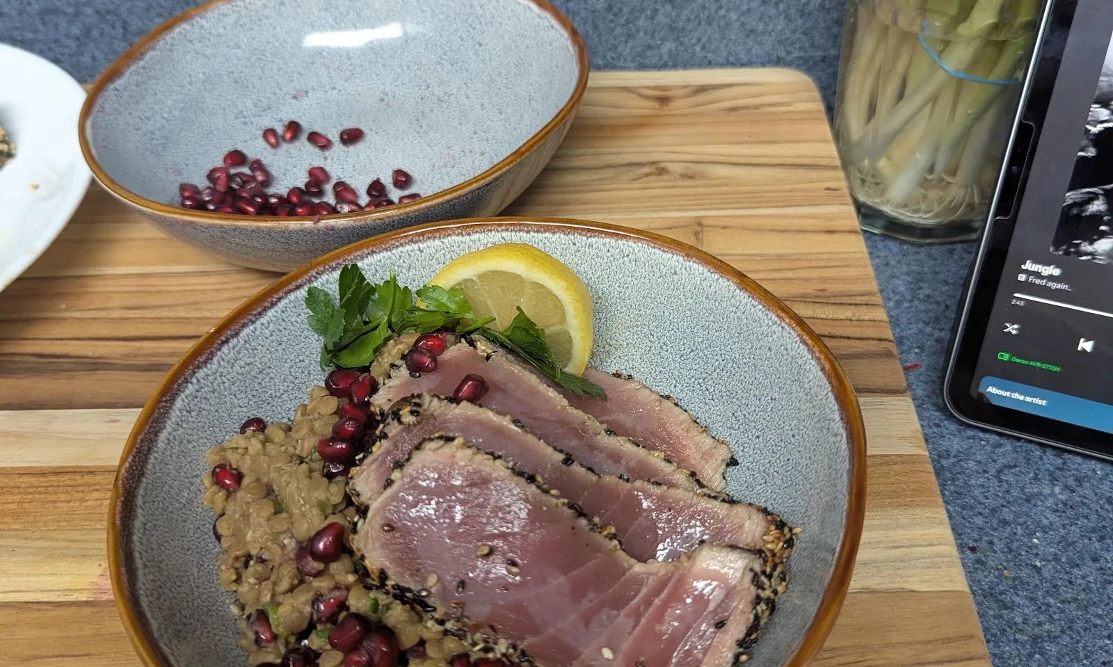 Seared sesame-crusted tuna slices over a lentil and pomegranate salad