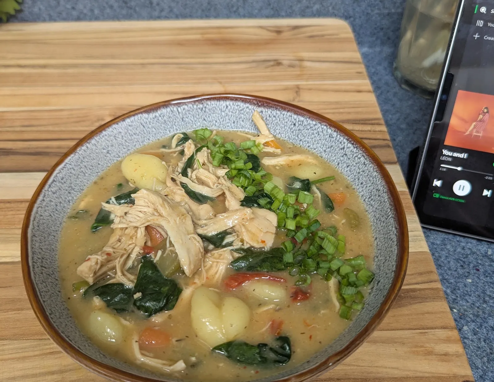 A bowl of creamy chicken and gnocchi soup with spinach